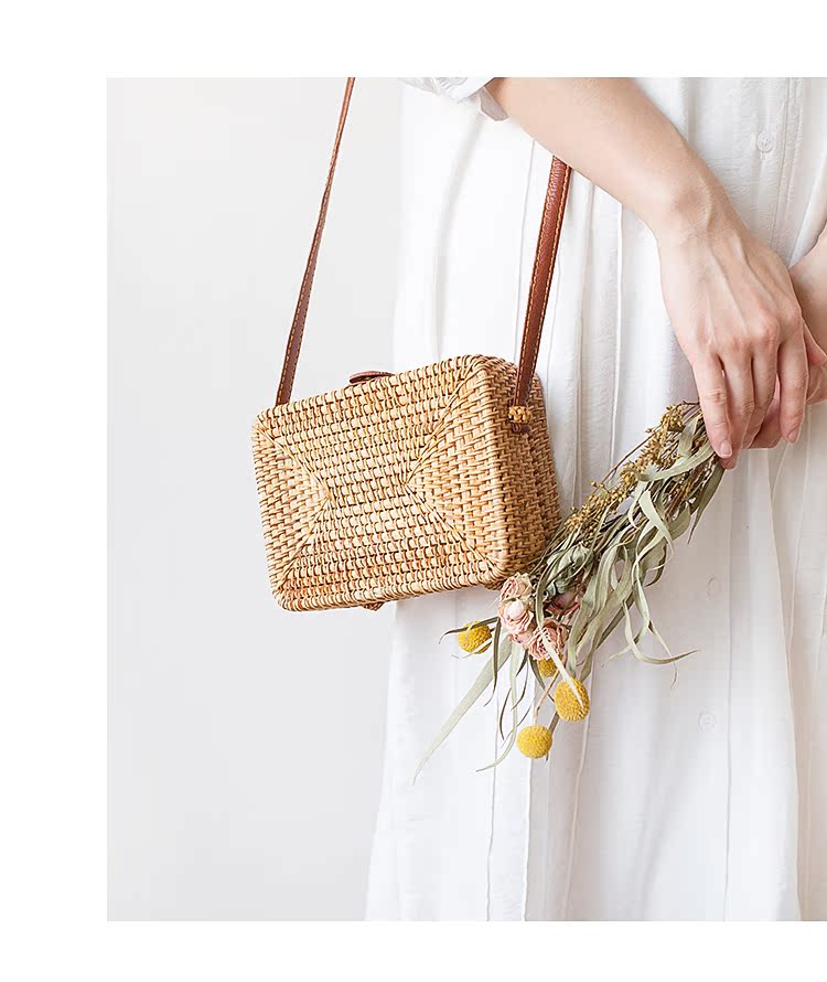 Woman holding a stylish, natural woven Rattan Box Bag with a floral bouquet, showcasing boho charm and functionality for casual outings.